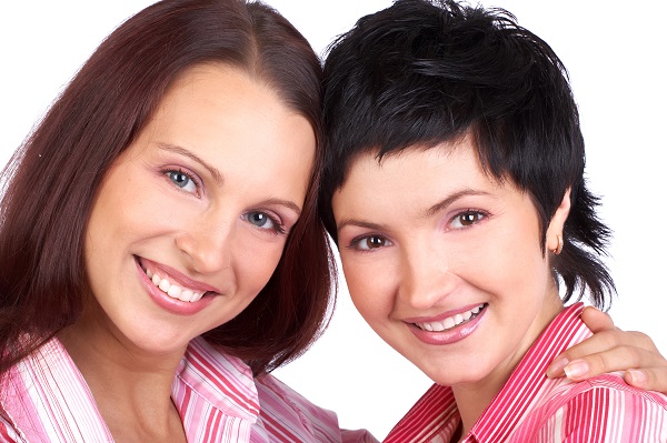 Happy young women friends smiling. Over white background