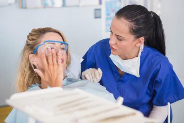 stock image of dental patient with mask speaking with dentist